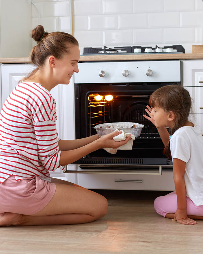 Mother And Daughter baking in propane oven